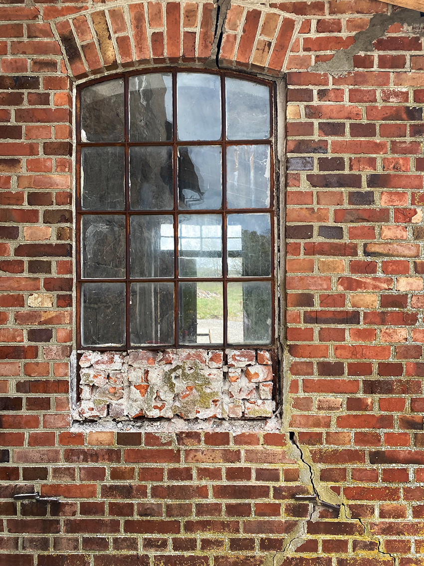 Gammalt fönster i en murad vägg