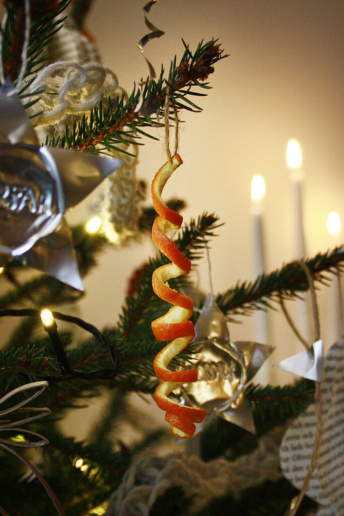 En apelsinskalsspiral hänger i julgranen.